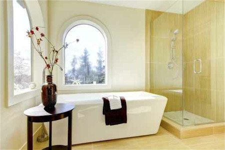 White master bathroom with arch window near bathtub