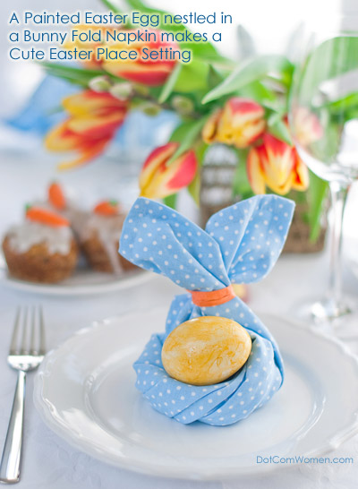 Easter Place Setting with a Bunny Folded Blue, Polka Dotted Napkin holding a Painted Egg