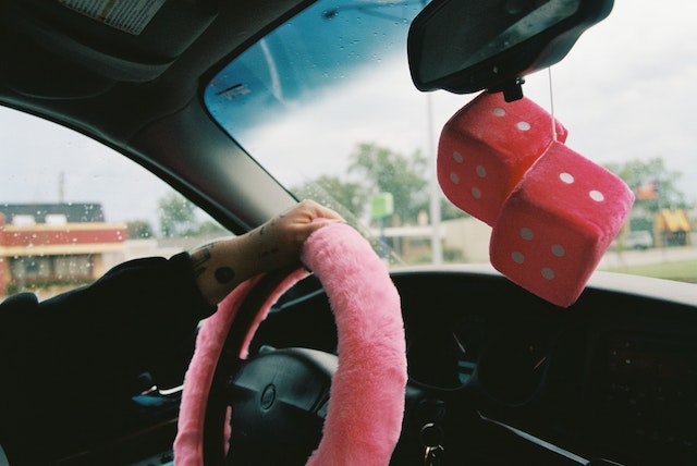pink steering wheel cover and dice toy